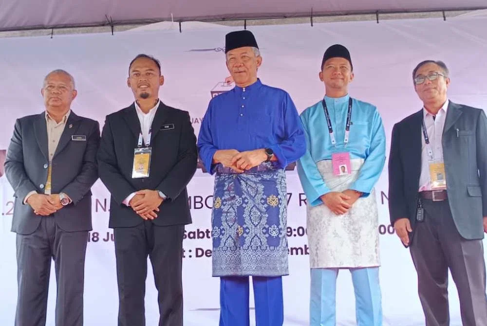 Calon PH, Dr Azizul Hakim Mahdi (dua dari kanan) dan Timbalan Pengerusi BN merangkap Timbalan Presiden UMNO, Datuk Seri Mohamad Hasan (tiga dari kiri) ketika diumumkan sebagai calon satu lawan satu di DUN Rantau selepas proses penamaan calon di Dewan Seri Rembau pada Sabtu.