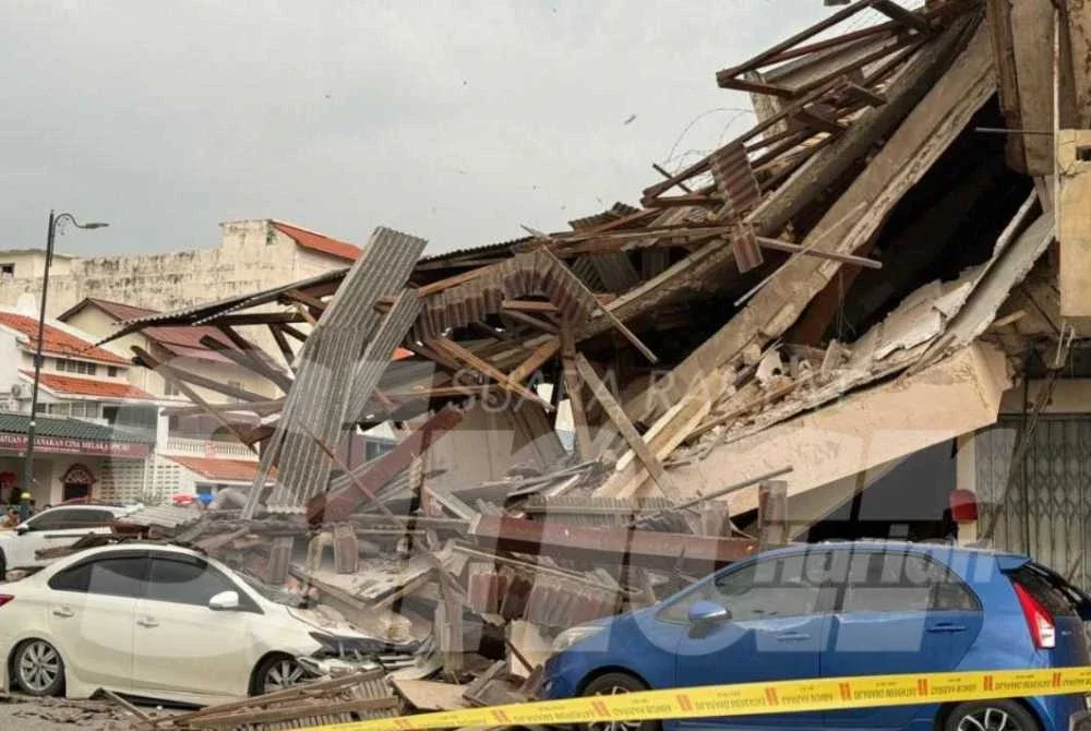 Keadaan dua kereta terjejas akibat runtuhan bangunan rumah kedai pada Sabtu. Foto: Sinar.