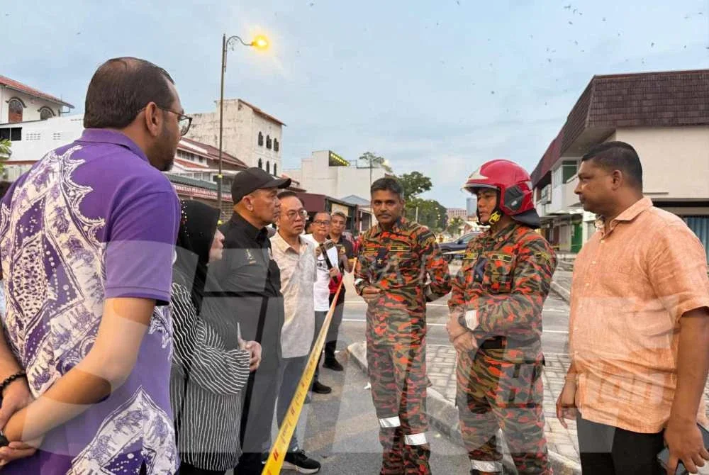 Chee Leong menunjukkan bangunan rumah kedai yang runtuh dalam kejadian Sabtu.Foto: Sinar.