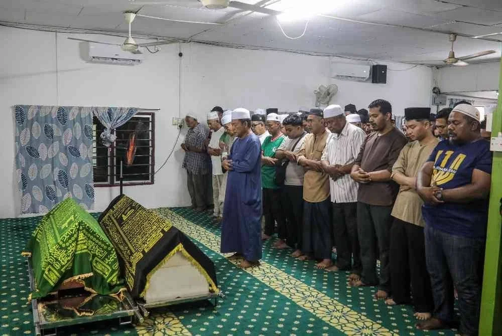 Orang ramai dan ahli keluarga melakukan solat jenazah Nur Atikah Abdullah, 28, dan sepupunya Muhammad Aariz Daniel, 3, yang terkorban dalam kejadian fenomena kepala air di Sungai Sedim, Kulim, semalam, di Tanah Perkuburan Islam Kampung Palas, Kangar, hari ini. Foto Bernama