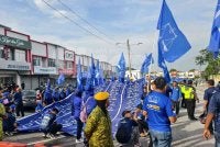 Bendera gergasi berwarna biru yang dikibarkan menuju pusat penamaan calon itu menjadi tumpuan orang ramai dan memeriahkan lagi kehadiran ratusan penyokong BN daripada pelbagai kaum.