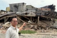Chee Leong menunjukkan bangunan rumah kedai yang runtuh dalam kejadian Sabtu