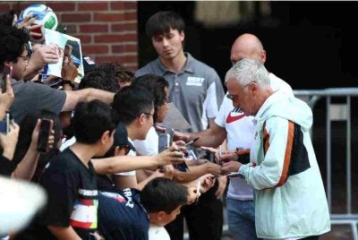 Deschamps (kanan) menandatangani autograf ketika skuad Les Bleus meninggalkan hotel di Boston untuk menuju ke Miami menjelang aksi penentuan tempat ketiga Piala Dunia 2026 menentang England.