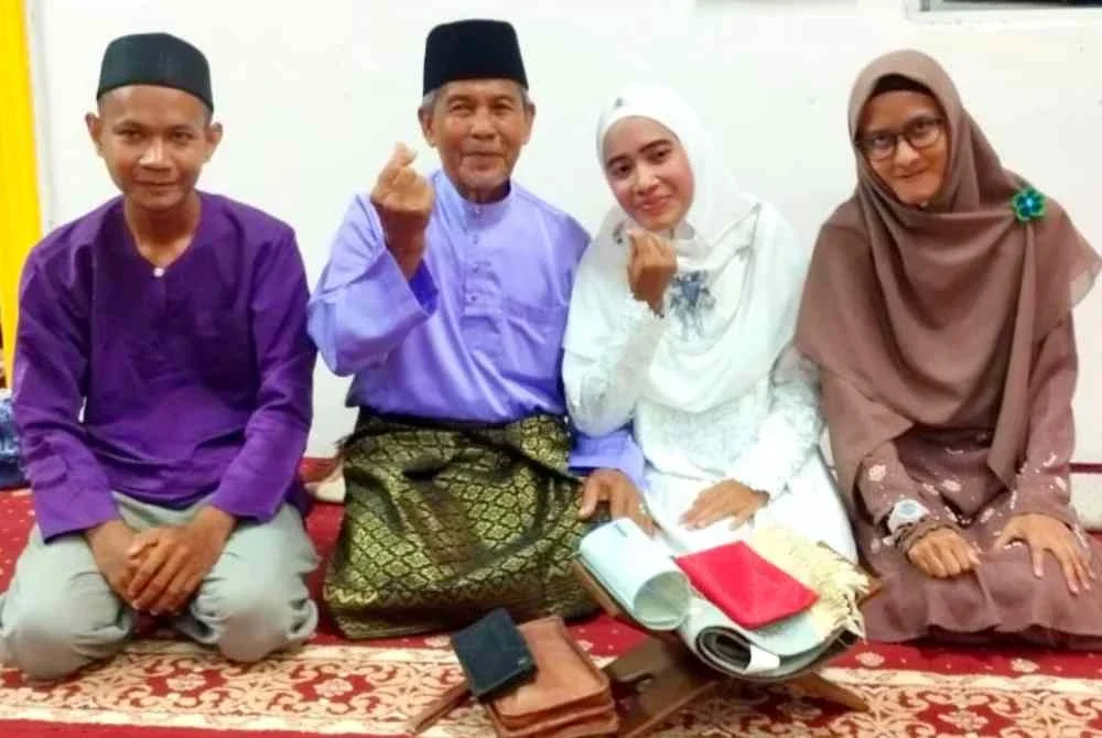 Wan Nor Fatihah dan suami bersama ahli keluarga semasa majlis akad nikah mereka pada 24 Jun lalu.
.