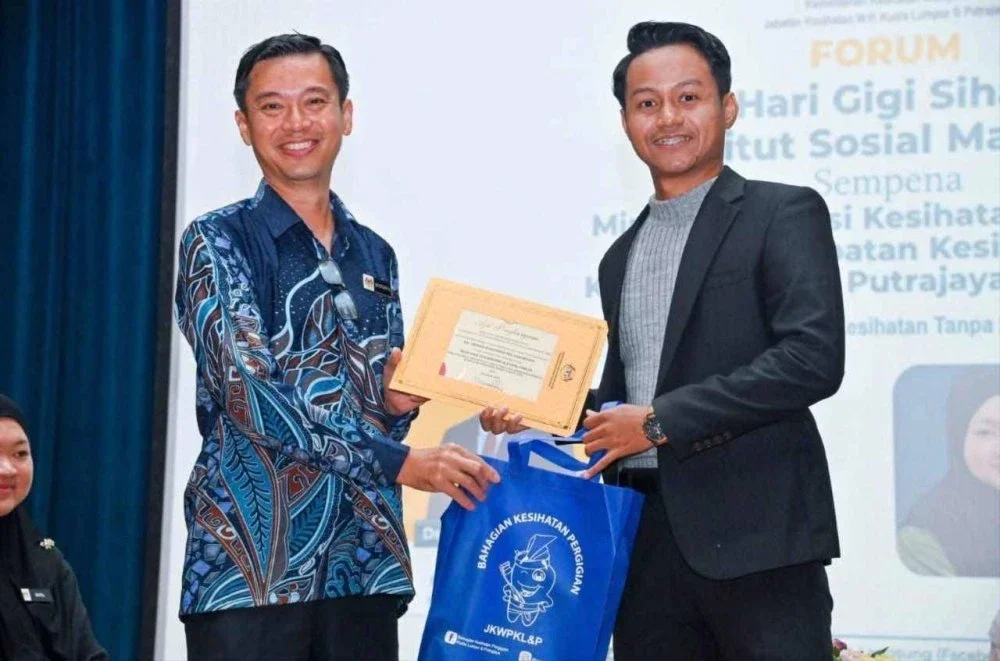 Timbalan Pengarah Kesihatan (Pergigian) Wilayah Persekutuan Kuala Lumpur dan Putrajaya, Dr Mustaffa Jaapar menyampaikan sijil penghargaan kepada Ahmad Rafiuddin atas penglibatan dalam Forum Kesihatan Pergigian sempena Program Hari Gigi Sihat Institut Sosial Malaysia.