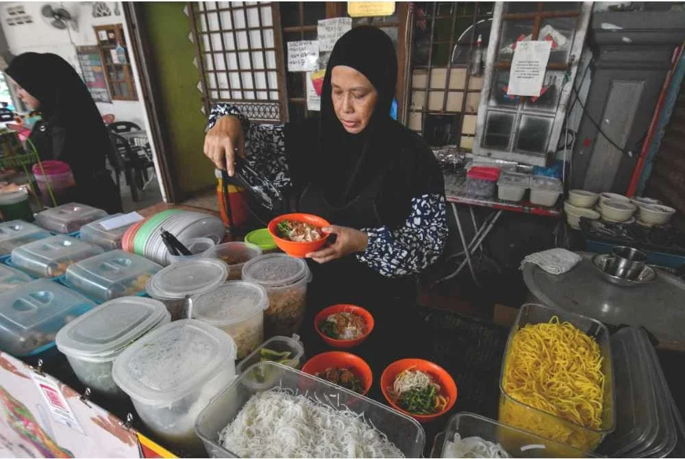Demi berkongsi rezeki Aminah kekal menjual makanan pada harga RM1 semangkuk sejak hampir sedekad lalu. Foto Bernama