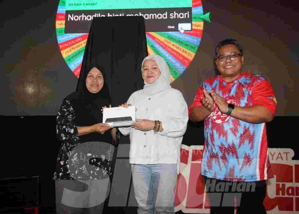Nor Hadila (kiri) menerima hadiah cabutan bertuah daripada Ketua Pegawai Eksekutif Grup Sinar Karangkraf, Farah Hussamuddin (tengah) dan Ketua Pengarang Kumpulan Sinar Harian, Zamri Rambli dalam program Riuh BOLA SINAR x redOne Mobile x RTM di Restoran Hakim, Seksyen 7, Shah Alam pada Ahad. Foto: Rosli Talib