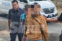 Suspek (berbaju coklat) dibawa polis ke mahkamah untuk permohonan reman.