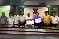 Ahmed Tarmize (kiri) bersama Nik Izani (lima dari kiri) pada majlis menandatangani kerjasama di antara COOP OKB dengan Koperasi UMK Berhad pada Ahad