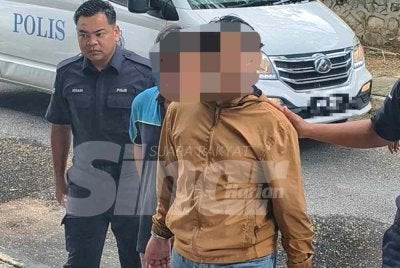 Suspek (berbaju coklat) dibawa polis ke mahkamah untuk permohonan reman.