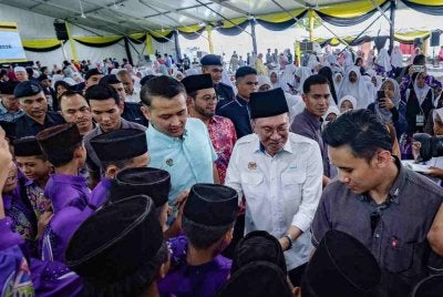 Anwar bersalaman bersama para pelajar ketika hadir pada Perasmian Himpunan Pondok dan Sekolah Agama Perak di Maahad Al -Ummah, Chemor, Ipoh hari ini. Foto: Bernama 