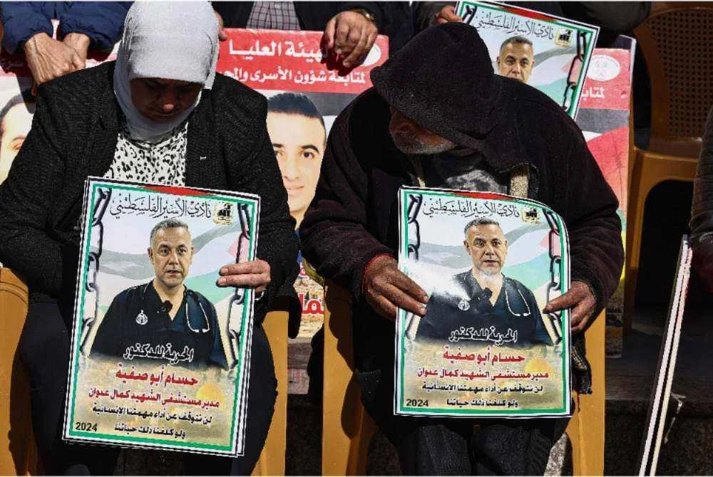 Penunjuk perasaan membawa plakad memaparkan potret Abu Safiya ketika perhimpunan solidariti di Ramallah. - Foto AFP