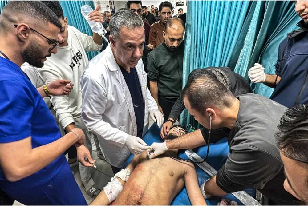 Abu Safiya (tengah) menyelia rawatan terhadap seorang mangsa yang cedera akibat serangan Israel di Beit Lahia pada November 2024. - Foto AFP