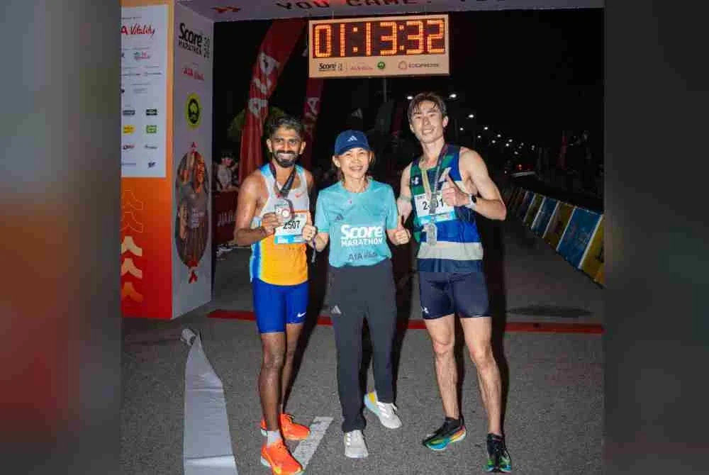 Patricia (tengah) bersama Prabudass (kiri) sejurus menamatkan saingan acara 21km SCORE Marathon 2026 di Putrajaya. Foto: Penganjur