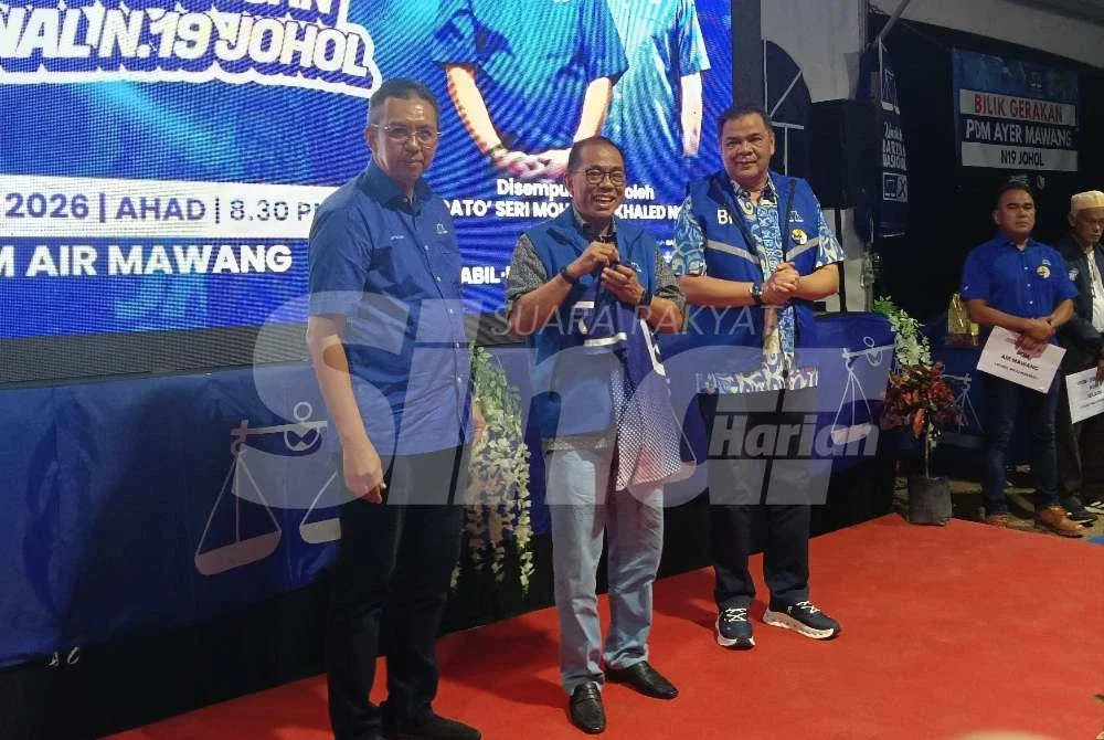 Saiful Yazan (kiri) menyerahkan baju kepada Mohamed Khaled sebagai simbolik pelancaran jentera BN Johol.