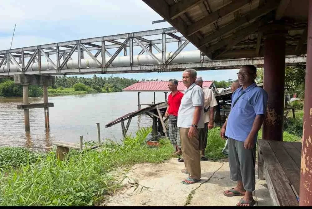 Abdullah (dua dari kanan) turut berada di sungai bagi menanti perkembangan khabar Rosnani. FOTO SINAR HARIAN - ADILA SHARINNI WAHID
