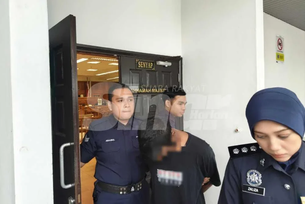Tertuduh ketika dibawa keluar dari Mahkamah Sesyen Ayer Keroh pada Isnin.