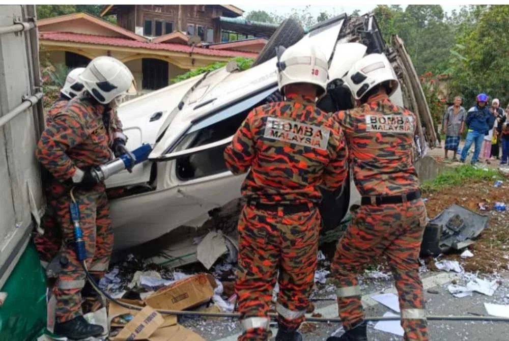 Anggota bomba mengeluarkan mangsa yang tersepit. Foto Bomba