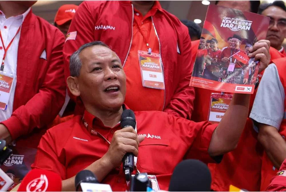 Aminuddin menunjuk buku Manifesto ketika sidang akhbar Majlis Peluncuran Manifesto Pakatan Harapan di sebuah hotel hari ini. - Foto: Bernama