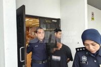 Tertuduh ketika dibawa keluar dari Mahkamah Sesyen Ayer Keroh pada Isnin.