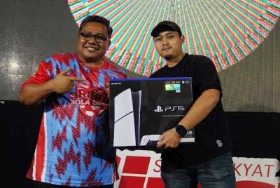 Danish ketika menerima hadiah cabutan bertuah disampaikan Ketua Pengarang Kumpulan Sinar Harian, Zamri Rambli.