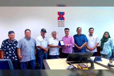 Ahmed Tarmize (dua dari kiri) bersama Nik Izani (empat dari kiri) dan Arham (empat dari kanan) pada majlis jalinan kerjasama strategik COOP OKB dan FTKW-UMK pada Ahad.