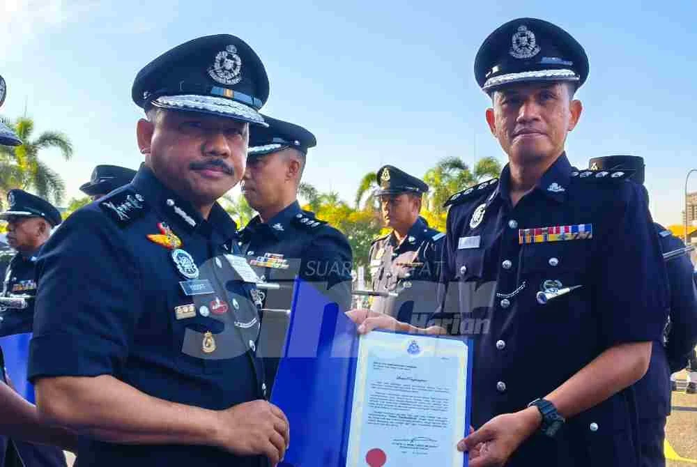 Mohd Yusoff (kiri) menyampaikan surat penghargaan kepada pegawai semasa perhimpunan bulanan di IPK Kelantan pada Selasa.