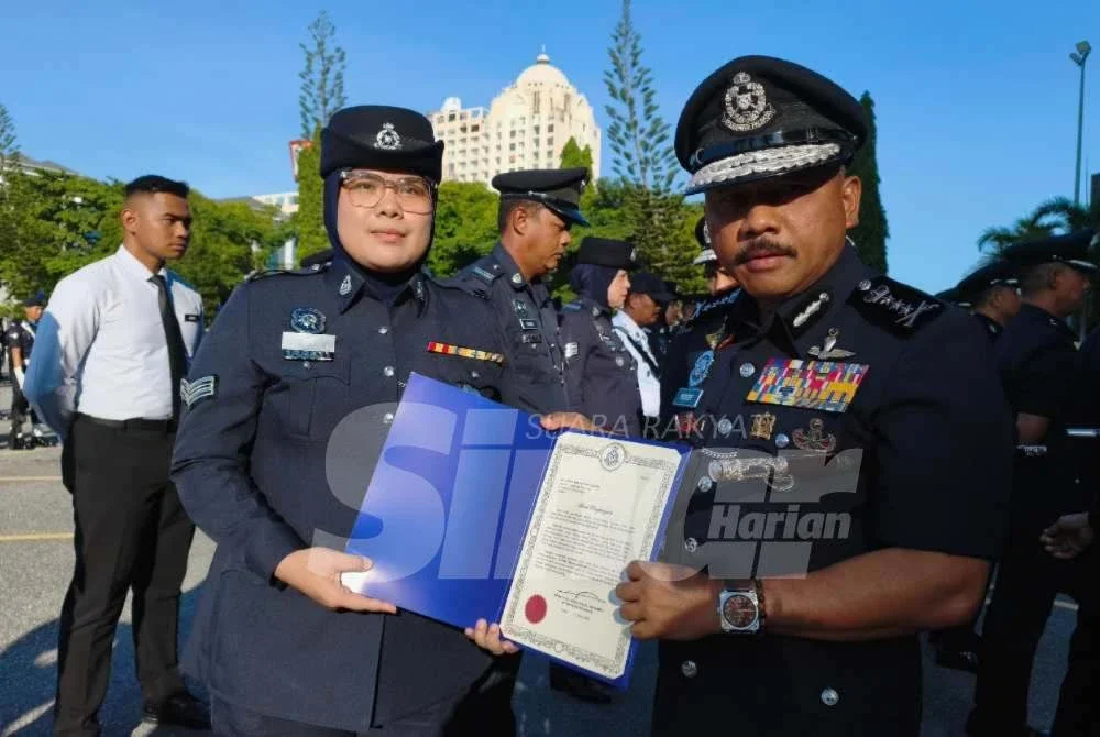 Mohd Yusoff (kanan) menyampaikan surat penghargaan kepada pegawai semasa perhimpunan bulanan di IPK Kelantan pada Selasa. Foto SINAR HARIAN/HAZELEN LIANA KAMARUDIN