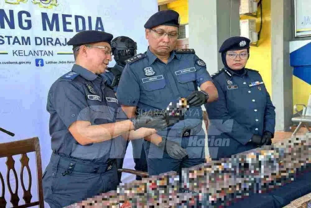 Mohd Hisham (tengah) memeriksa label pada kotak rokok. 
