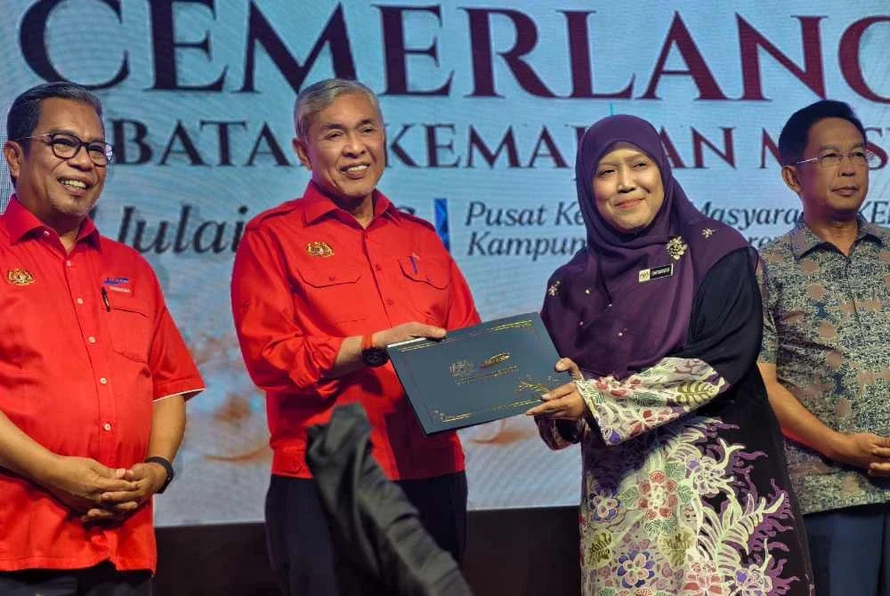 Ahmad Zahid (dua dari kiri) menyerahkan Anugerah Perkhidmatan Cemerlang kepada kakitangan Kemas Negeri Sembilan.
