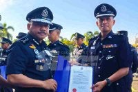 Mohd Yusoff (kiri) menyampaikan surat penghargaan kepada pegawai semasa perhimpunan bulanan di IPK Kelantan pada Selasa.