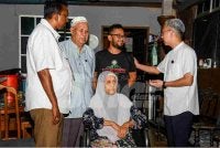 Manivanan (kiri), Fahmi (kanan) ketika Ziarah Kasih di Felda Palong 2 pada Isnin.