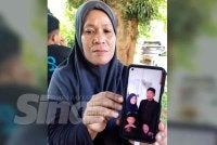 Noraida menunjukkan gambar arwah suami ketika ditemui di Unit Forensik Hospital Tanah Merah pada Selasa.