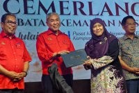 Ahmad Zahid (dua dari kiri) menyerahkan Anugerah Perkhidmatan Cemerlang kepada kakitangan Kemas Negeri Sembilan.