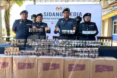 Mohd Hisham (dua dari kanan) menunjukkan rokok yang dirampas. 