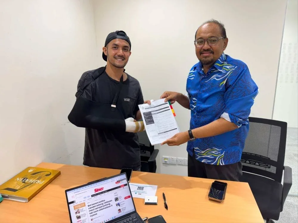 Muhammad Farris (kiri) menerima faedah menerusi menerusi skim LINDUNG 24 Jam oleh PERKESO.
