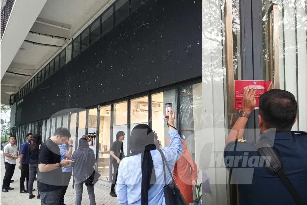 Petugas media berkumpul di luar premis Network School.