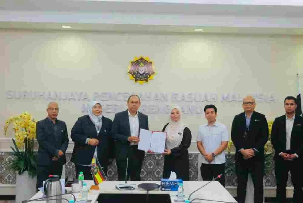 Hazrul Shazreen (tiga dari kiri) menerima Laporan Penambahbaikan Tatakelola yang ditandatangani Safura di Pejabat SPRM Terengganu, di Kuala Terengganu pada Rabu.