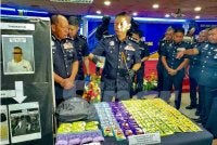 Dennis (tengah) menunjukkan dadah jenis MDMA yang dirampas dalam operasi, pada Ahad lalu.