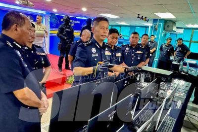 Dennis (tengah) menunjukkan barangan yang dirampas dalam lima serbuan melibatkan pusat panggilan palsu di seluruh Pulau Pinang.
