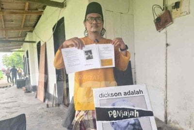 Islah Wahyudi menunjukkan manifesto yang ditawarkannya kepada pengundi pada sidang media di Stesen Keretapi Lama Dickson pada Selasa.