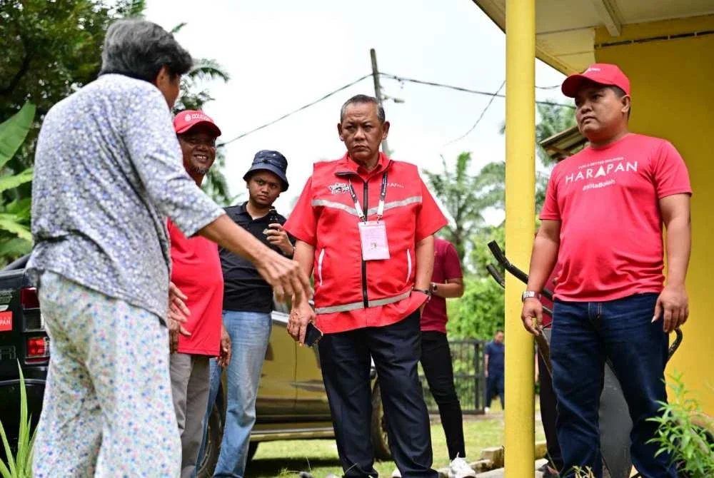 Aminuddin (tengah) bertemu pengundi di DUN Linggi. Foto Facebook Aminuddin