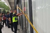 Anggota penguat kuasa Majlis Bandaraya Iskandar Puteri memasang pita kuning di salah satu premis Network School.