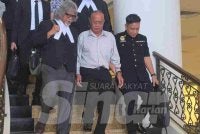 Tertuduh (tengah) diiringi peguamnya selepas keluar dari Mahkamah Sesyen Kota Kinabalu.
