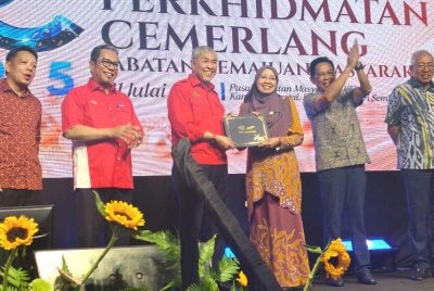 Ahmad Zahid (tiga dari kiri) menyampaikan Anugerah Perkhidmatan Cemerlang kepada kakitangan KEMAS.