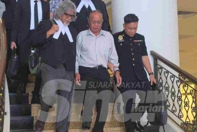 Tertuduh (tengah) diiringi peguamnya selepas keluar dari Mahkamah Sesyen Kota Kinabalu.