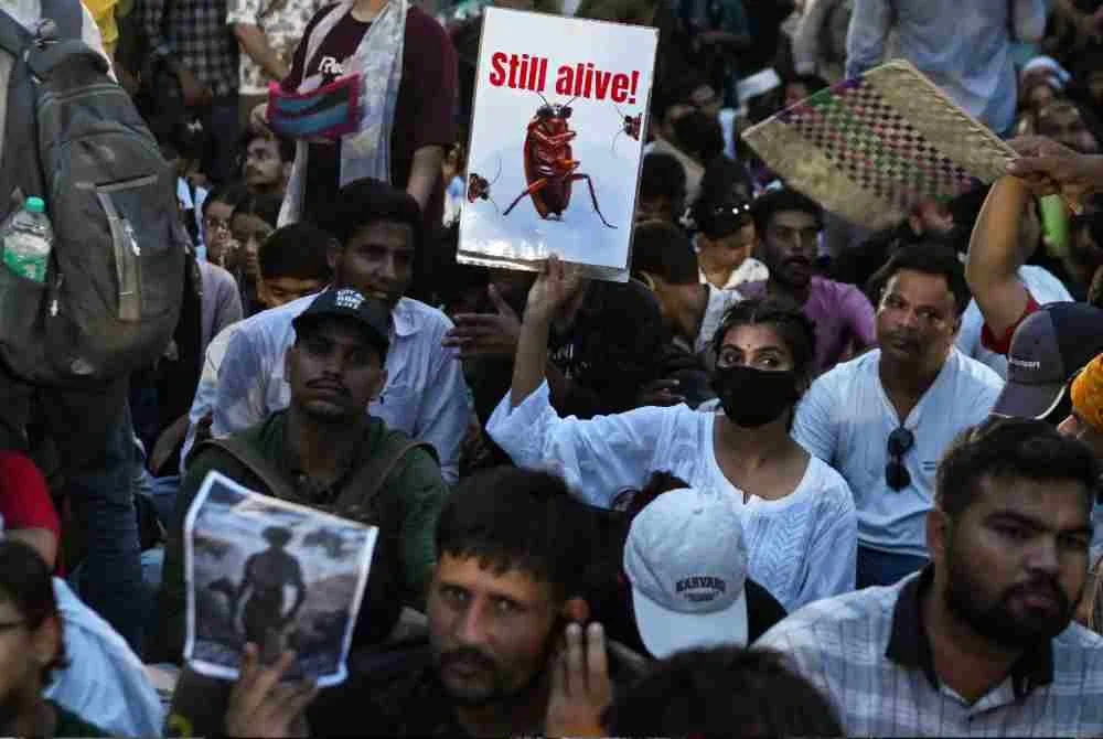 Penyokong CJP memegang plakad ketika protes menuntut peletakan jawatan Pradhan, di Jantar Mantar, New Delhi.