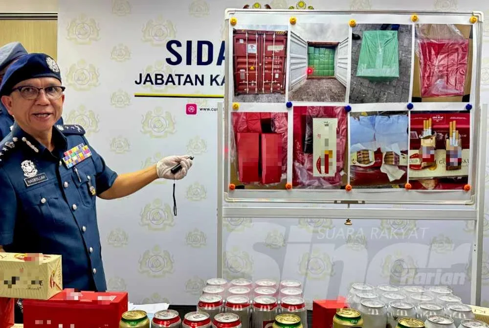Hasbollah menunjukkan rokok seludup yang dijumpai dalam sebuah kontena dalam operasi pada Jun lalu.