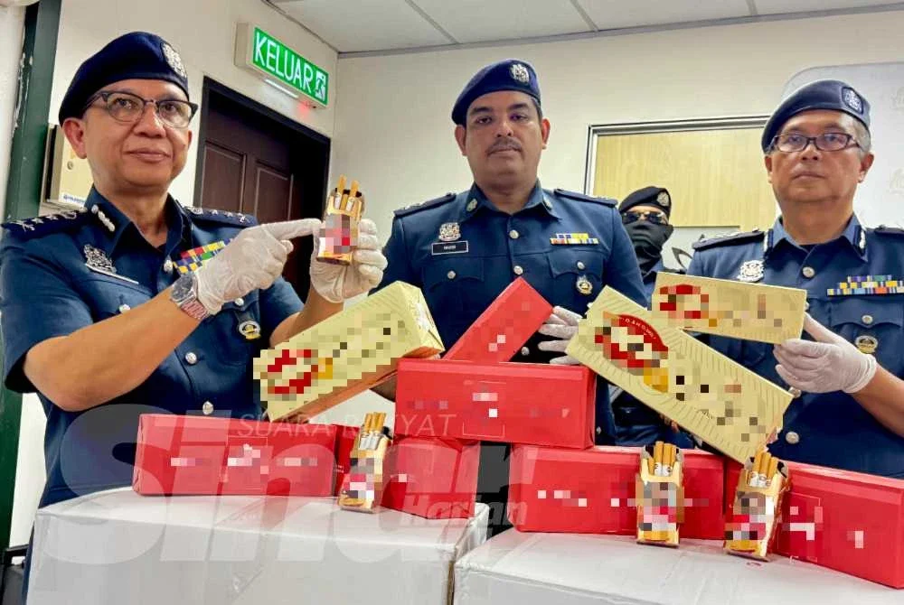 Hasbollah (kiri) menunjukkan sebahagian rokok seludup bernilai RM9.14 juta yang dirampas pada sidang media Jumaat.