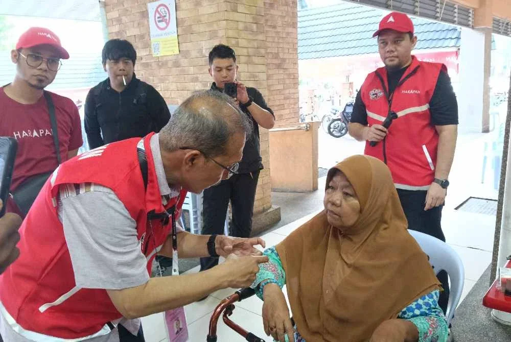 Muhammad Nazri berkesempatan beramah mesra dengan seorang ibu tunggal yang juga Orang Kurang Upaya (OKU), Jumaah Mohd Alif, 68.